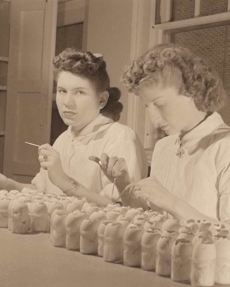 Two technicians at the vaccine bench at the U.S. Public Health Service's Rocky Mountain Laboratory, Hamilton, Montana; one looks up from her work (Library of Congress)