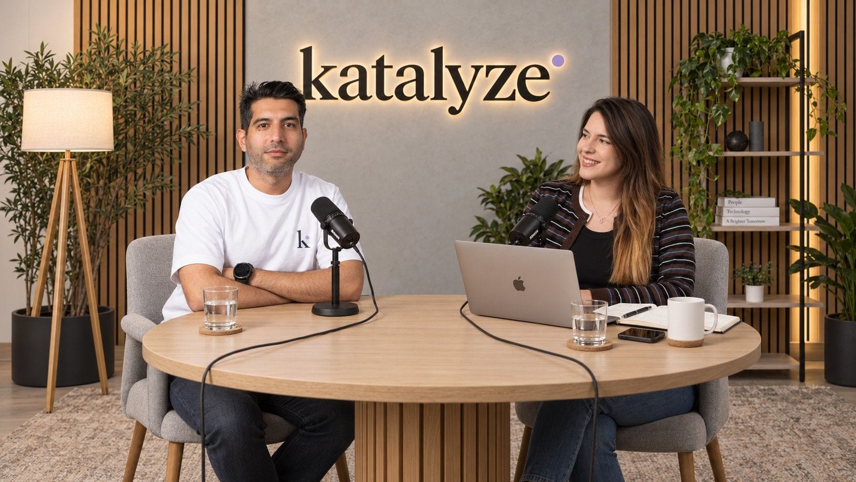 Reza Farahani and Alyse Gonthier at the table in the Katalyze studio, microphones between them